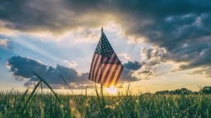 american flag with sunset behind